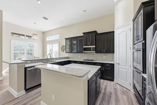 a kitchen with a stove a refrigerator and a kitchen island