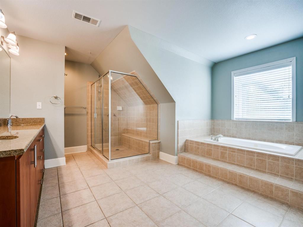 5707 Lewis Street Dallas, TX 75206 - Photo 11 of 11 Full bath featuring vanity, light tile patterned floors, a shower stall, and a garden tub