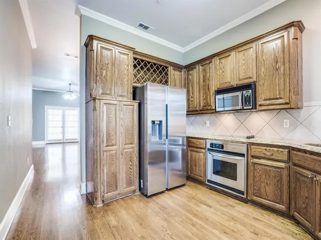 a kitchen with stainless steel appliances granite countertop a refrigerator microwave and stove top oven