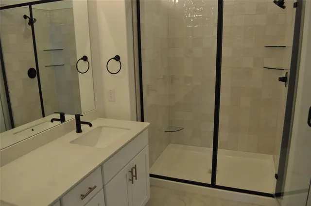 a bathroom with a shower sink and mirror
