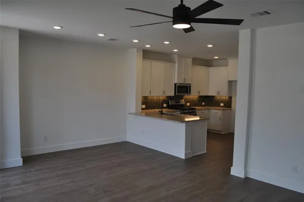 a kitchen with a refrigerator and white cabinets