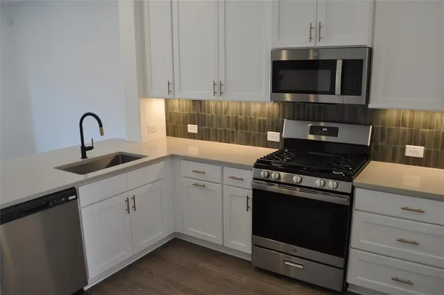 a kitchen with cabinets appliances and a sink