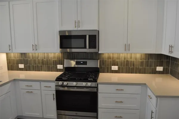 a kitchen with cabinets appliances and a sink