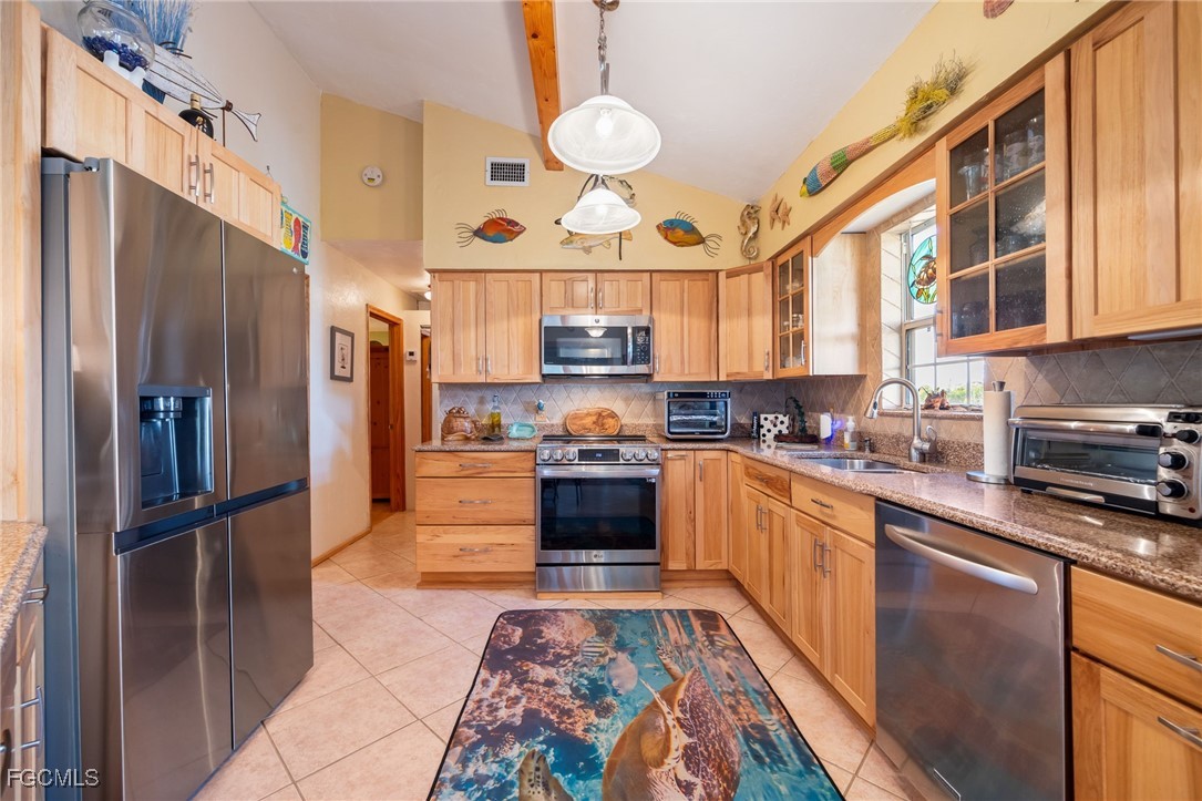 3374 York Road St. James City, FL 33956 - Photo 11 of 49 a kitchen with stainless steel appliances granite countertop a refrigerator and a stove top oven