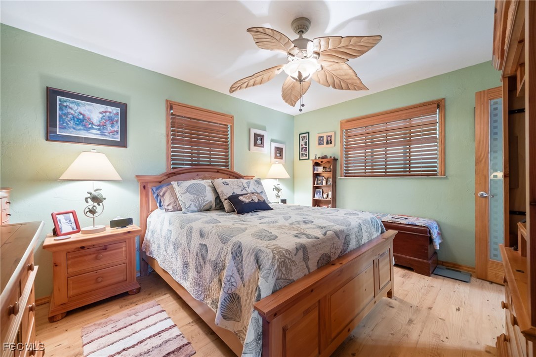 3374 York Road St. James City, FL 33956 - Photo 21 of 49 a bedroom with bed and a chandelier