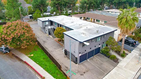 an aerial view of a house with a big yard and large trees