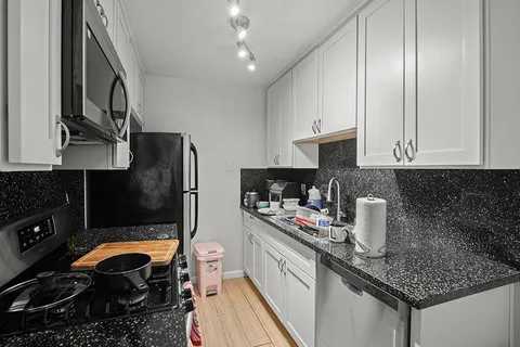 a kitchen with stainless steel appliances granite countertop a sink stove and cabinets