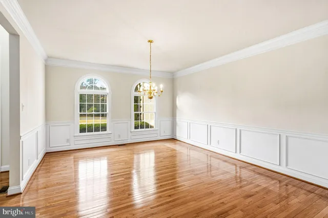 a view of a room with wooden floor staircase and kitchen view