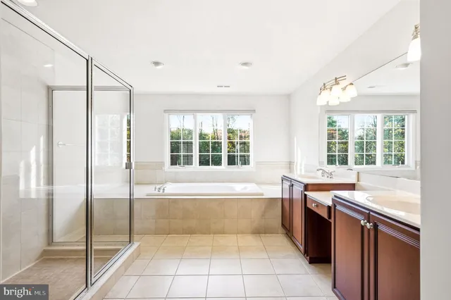 a spacious bathroom with a tub sink and mirror