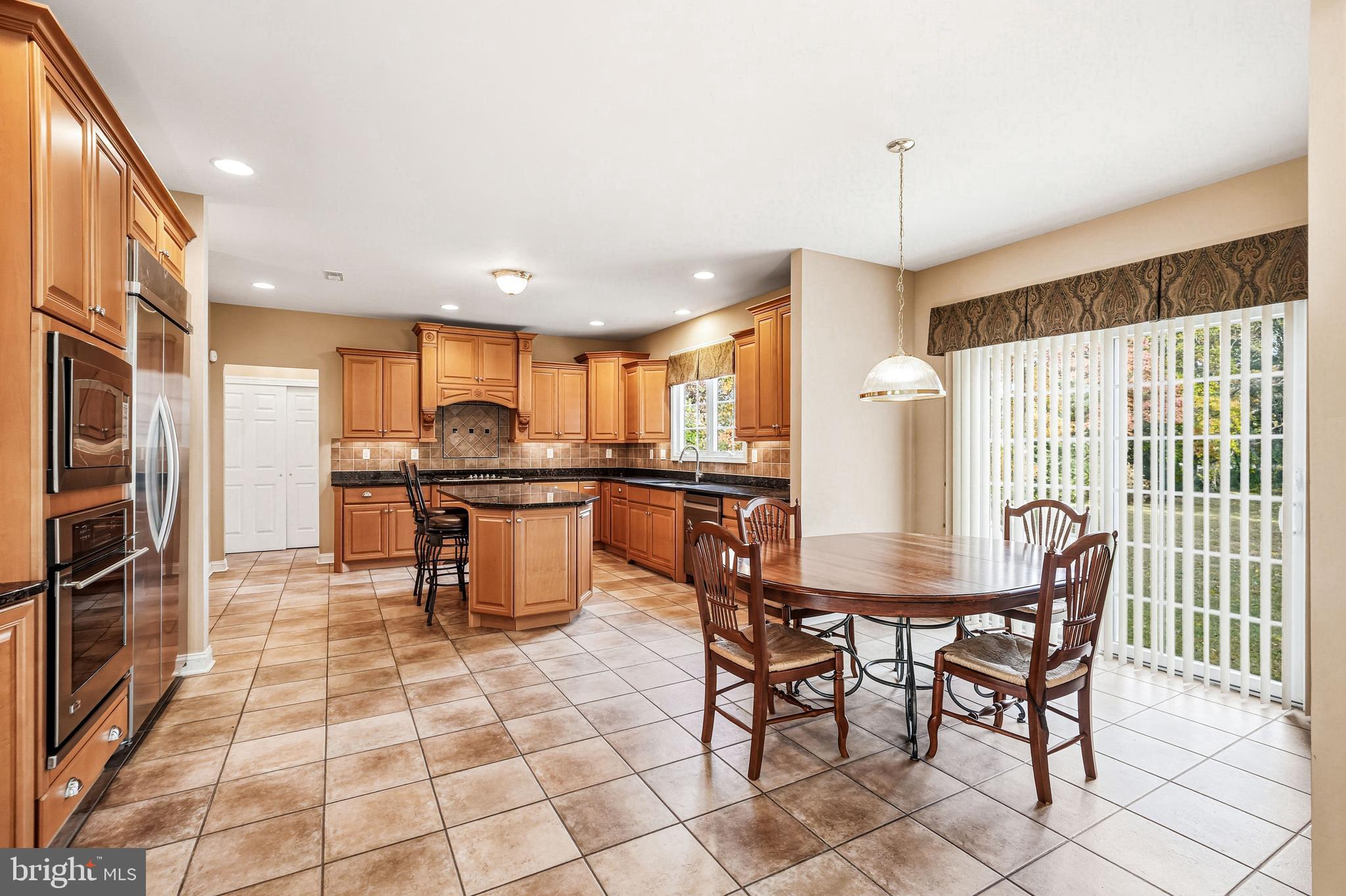950 Borton Landing Road Moorestown, NJ 08057 - Photo 7 of 53 a kitchen with stainless steel appliances a dining table chairs and a refrigerator