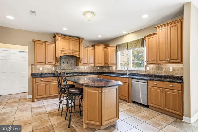 a kitchen with granite countertop sink window and cabinets