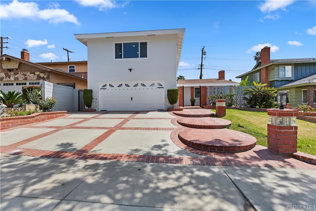 a view of a white house with a yard and potted plants