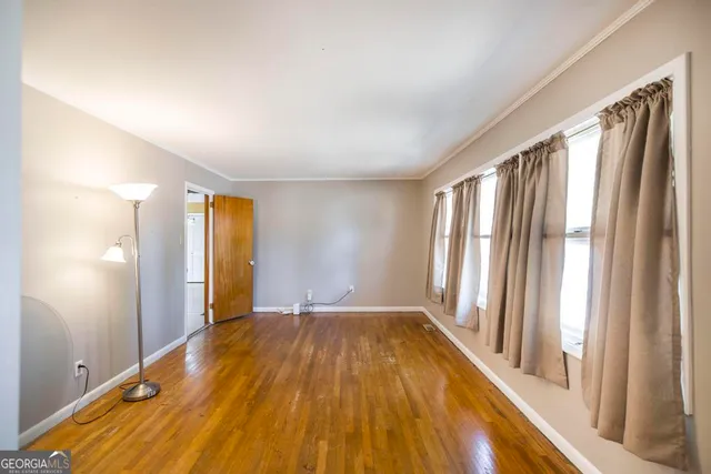 a view of a room with wooden floor and a window