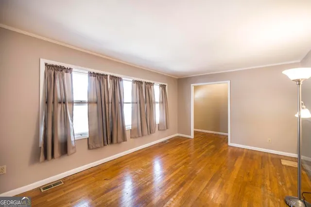 an empty room with wooden floor and a window