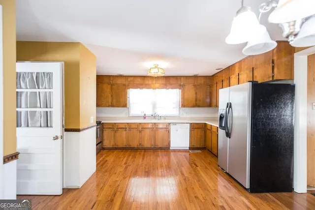a kitchen with a refrigerator and wooden floor