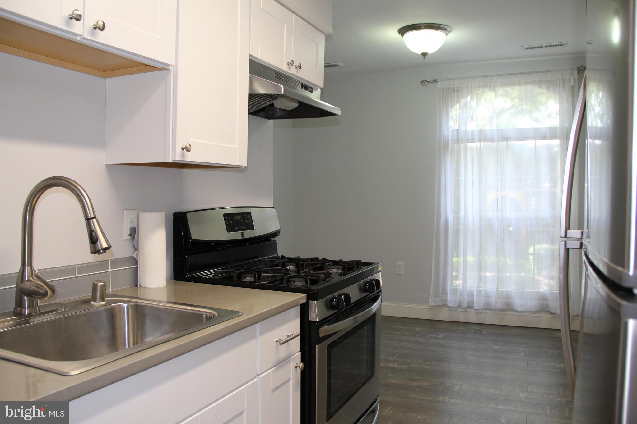 3360 Woodburn Road, Unit 23 Annandale, VA 22003 - Photo 39 of 50 a kitchen with granite countertop a sink stainless steel appliances and cabinets