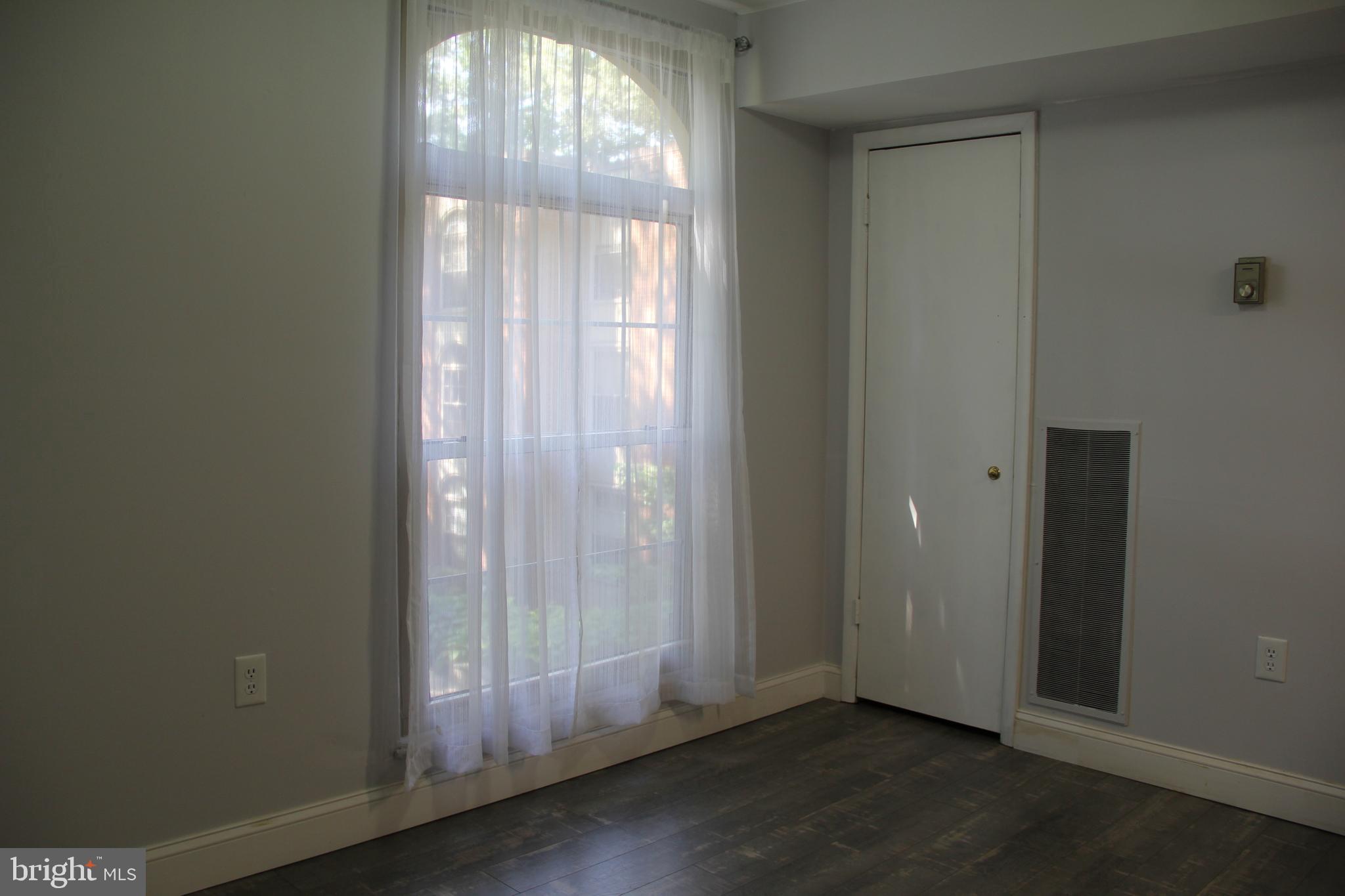 3360 Woodburn Road, Unit 23 Annandale, VA 22003 - Photo 9 of 50 an empty room with wooden floor and windows