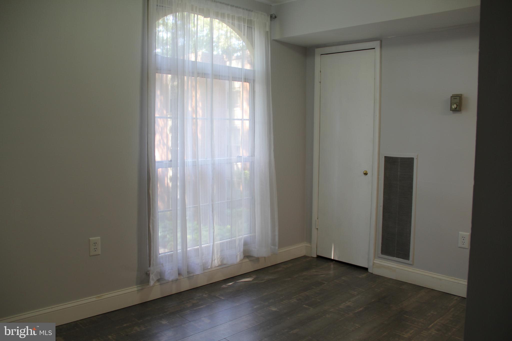 3360 Woodburn Road, Unit 23 Annandale, VA 22003 - Photo 10 of 50 an empty room with wooden floor door and windows