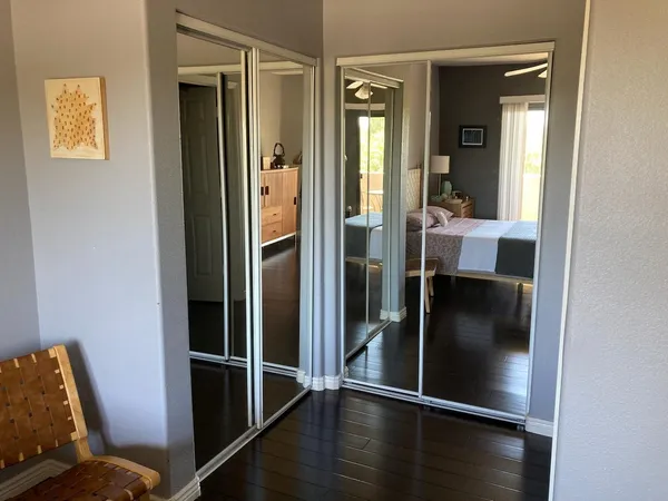 a view of a hallway with wooden floor and bathroom