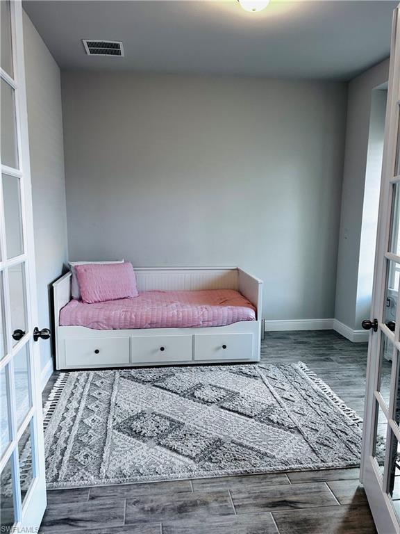 3444 Pilot Circle Naples, FL 34120 - Photo 5 of 13 a view of a bedroom with a bed and wooden floor