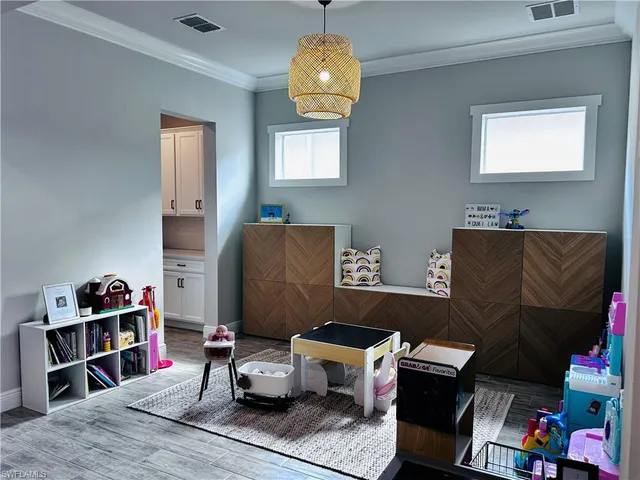 a living room with furniture a baby crib and a book shelf