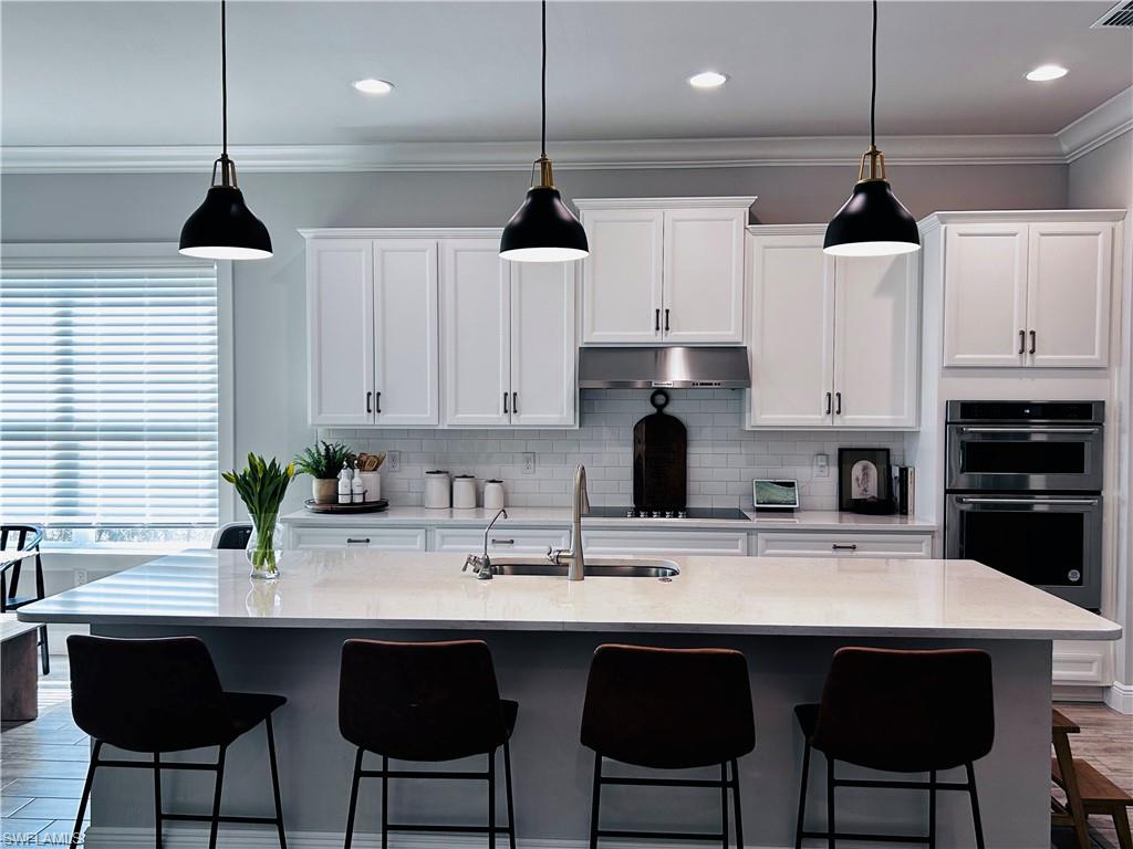 3444 Pilot Circle Naples, FL 34120 - Photo 7 of 13 a kitchen with stainless steel appliances a center island and a cabinets
