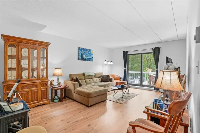 a living room with furniture flat screen tv and a large window