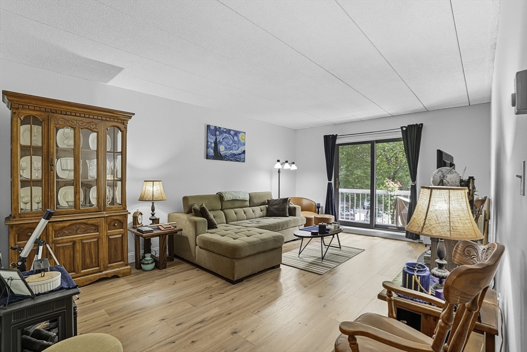 a living room with furniture flat screen tv and a large window