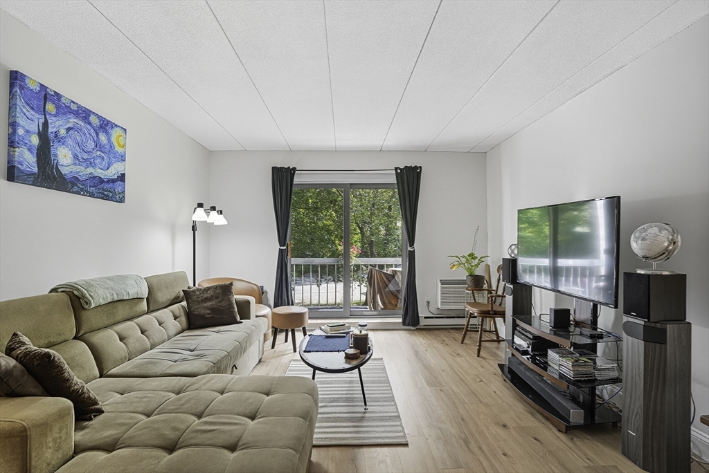 85 Commons Drive, Unit 210 Shrewsbury, MA 01545 - Photo 2 of 15 a living room with furniture and a flat screen tv