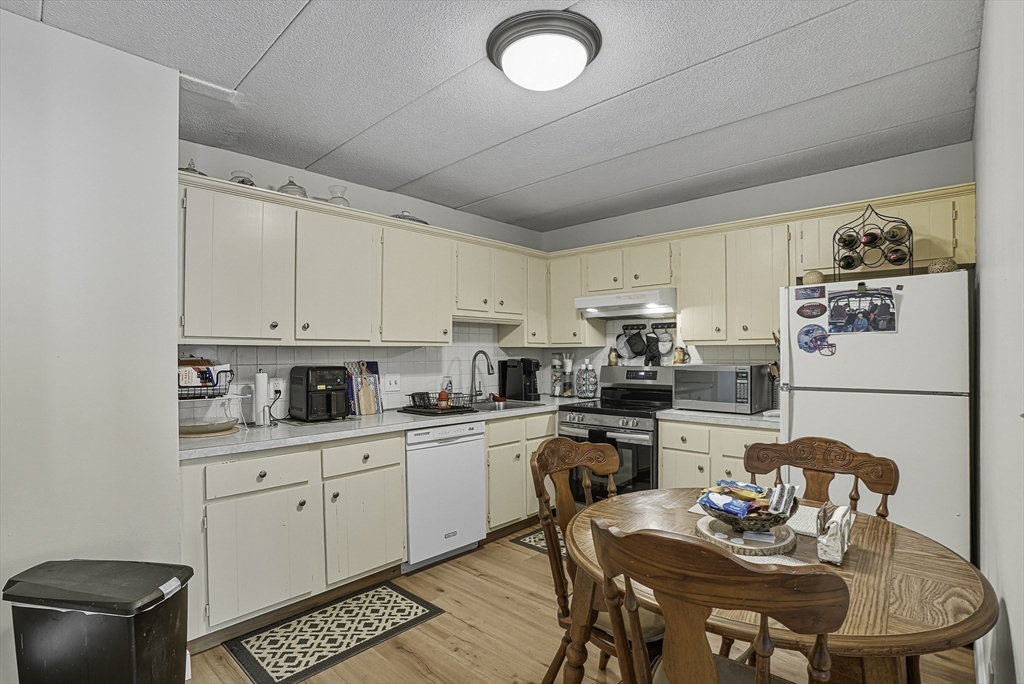85 Commons Drive, Unit 210 Shrewsbury, MA 01545 - Photo 4 of 15 a kitchen with stainless steel appliances granite countertop a stove a sink dishwasher and a refrigerator