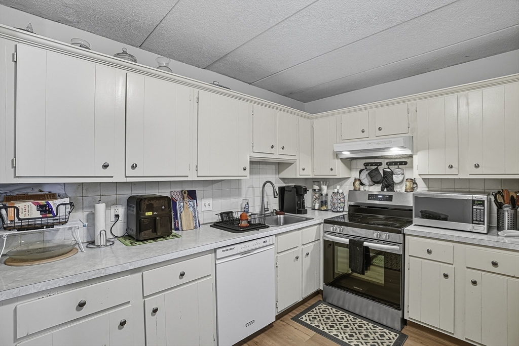 85 Commons Drive, Unit 210 Shrewsbury, MA 01545 - Photo 6 of 15 a kitchen with cabinets appliances a sink and a counter top