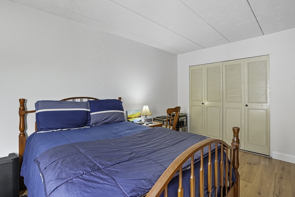 85 Commons Drive, Unit 210 Shrewsbury, MA 01545 - Photo 8 of 15 a bed room with a bed and a closet