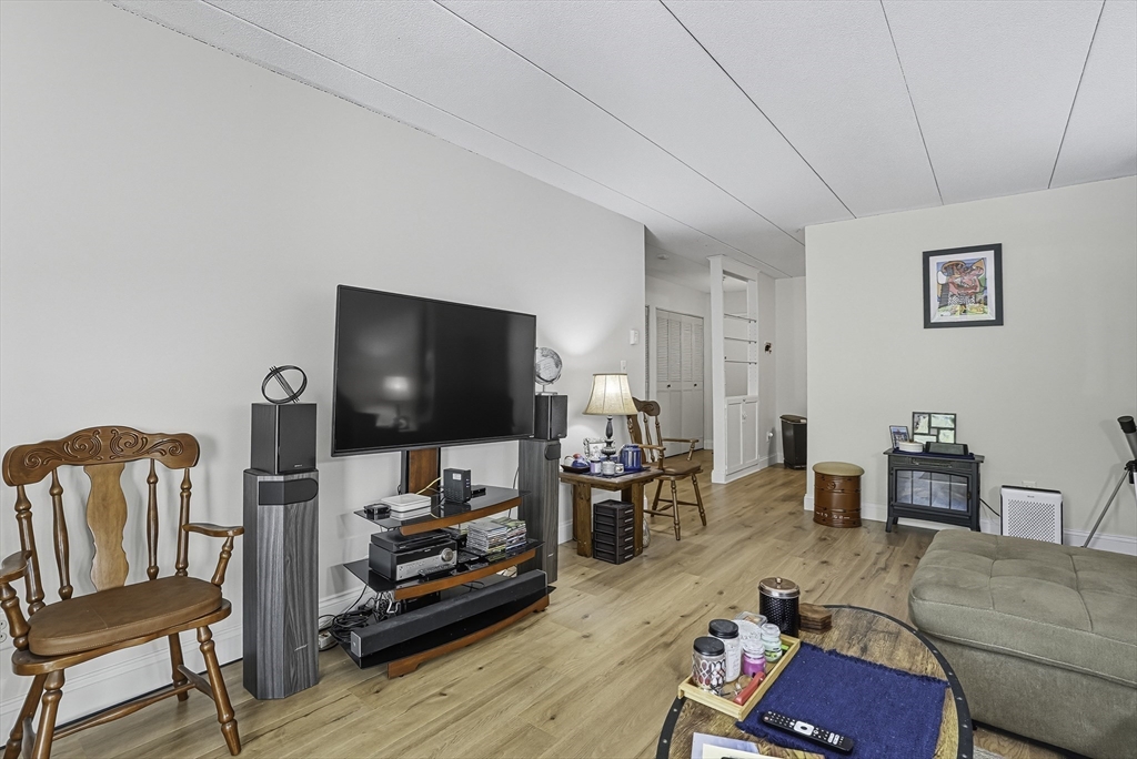85 Commons Drive, Unit 210 Shrewsbury, MA 01545 - Photo 9 of 15 a living room with furniture and a flat screen tv