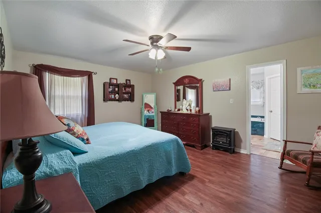 a bedroom with a bed and a dresser with wooden floor