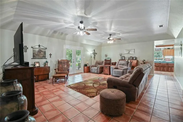 a living room with furniture a chandelier and a flat screen tv