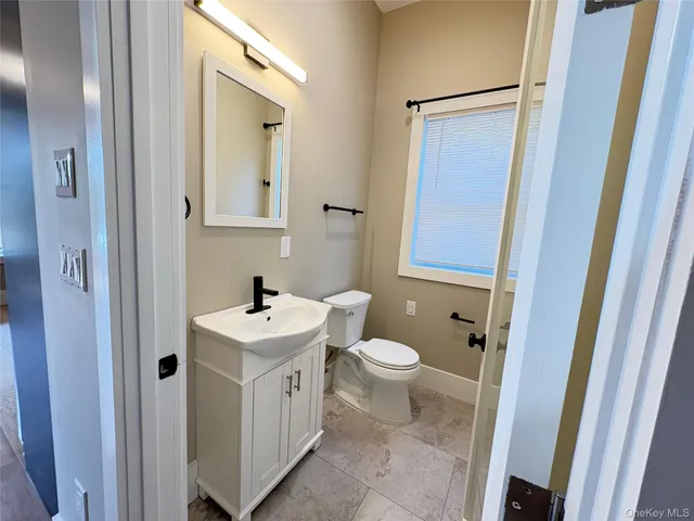 a bathroom with a sink a toilet and a mirror