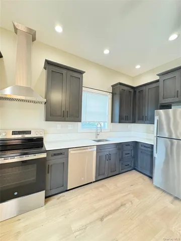 a large kitchen with granite countertop a white stove top oven and refrigerator