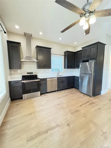 a large kitchen with stainless steel appliances kitchen island granite countertop a refrigerator oven a stove top oven with a sink and dishwasher
