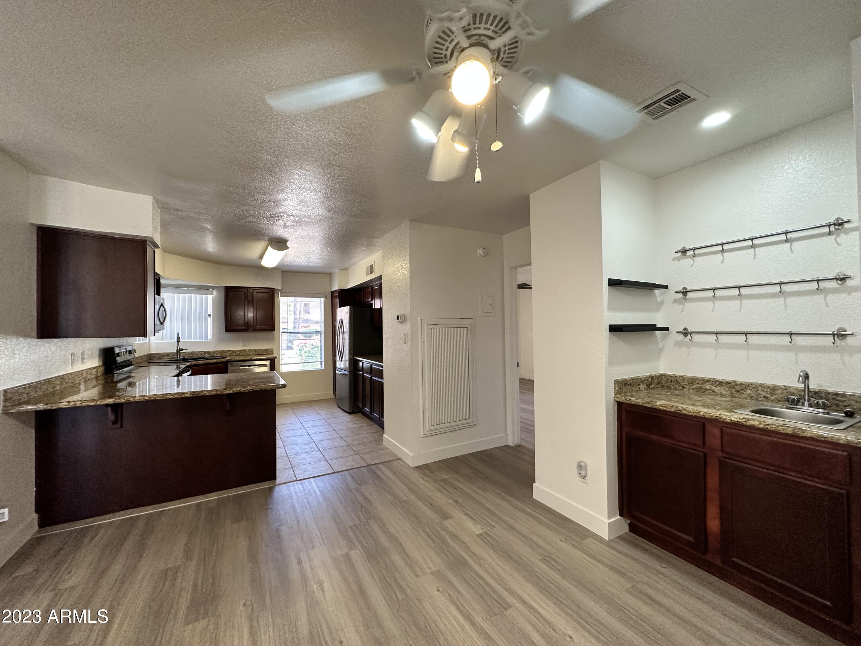 8787 East Mountain View Road, Unit 1103 Scottsdale, AZ 85258 - Photo 14 of 38 a large kitchen with stainless steel appliances kitchen island granite countertop a large counter top and stainless steel appliances