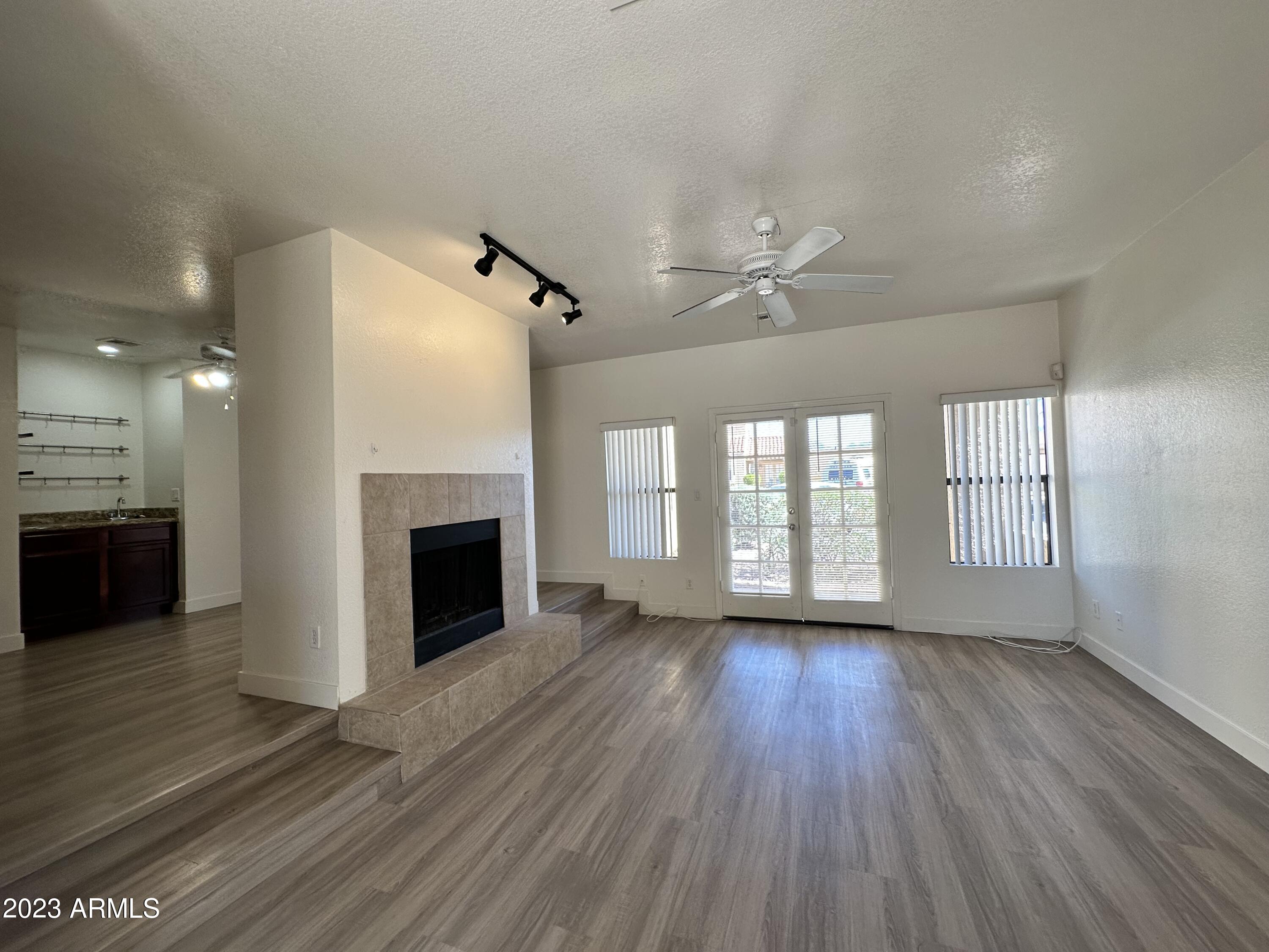 8787 East Mountain View Road, Unit 1103 Scottsdale, AZ 85258 - Photo 21 of 38 an empty room with wooden floor fireplace and windows