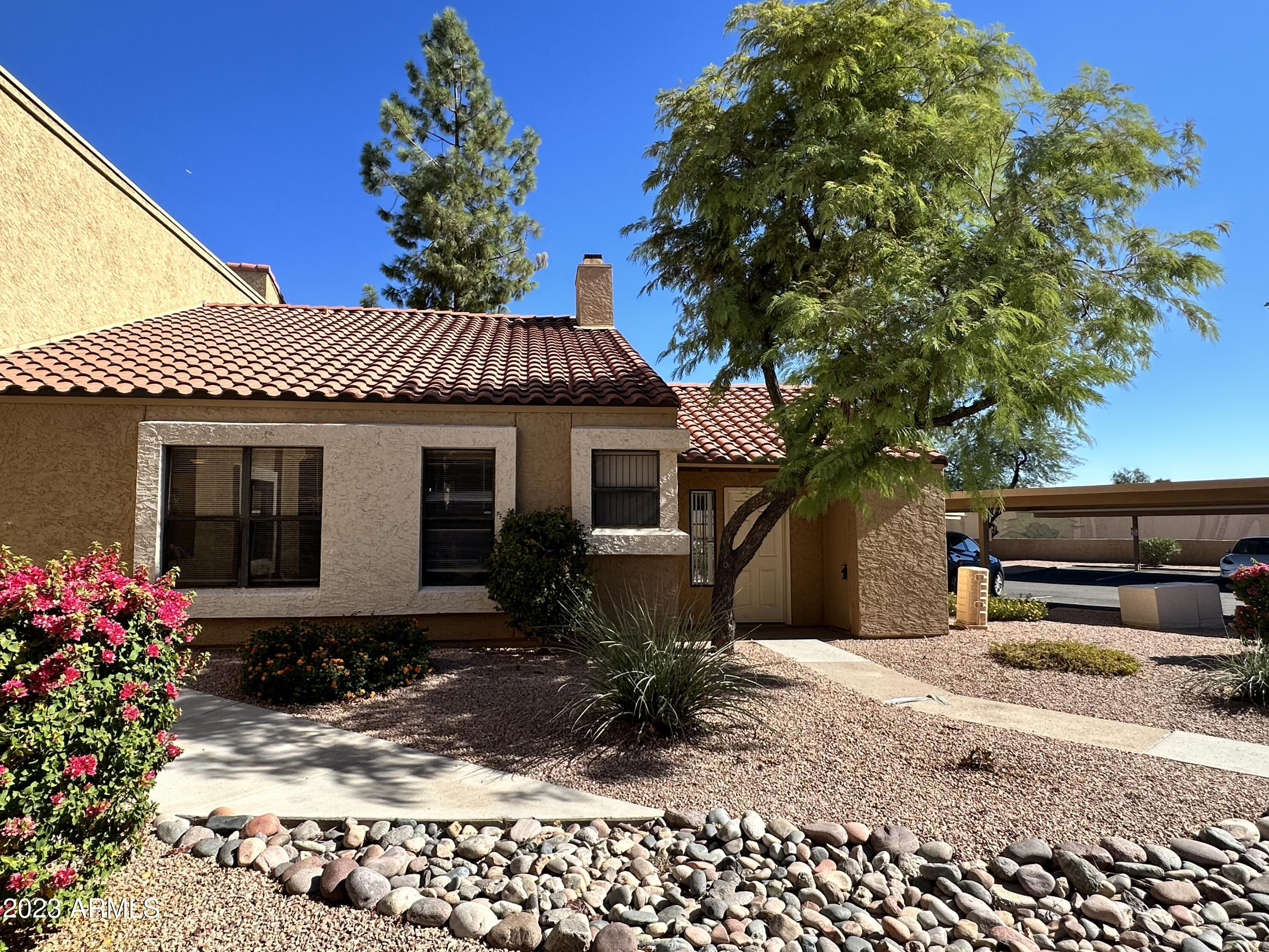 8787 East Mountain View Road, Unit 1103 Scottsdale, AZ 85258 - Photo 27 of 38 a front view of a house with a yard