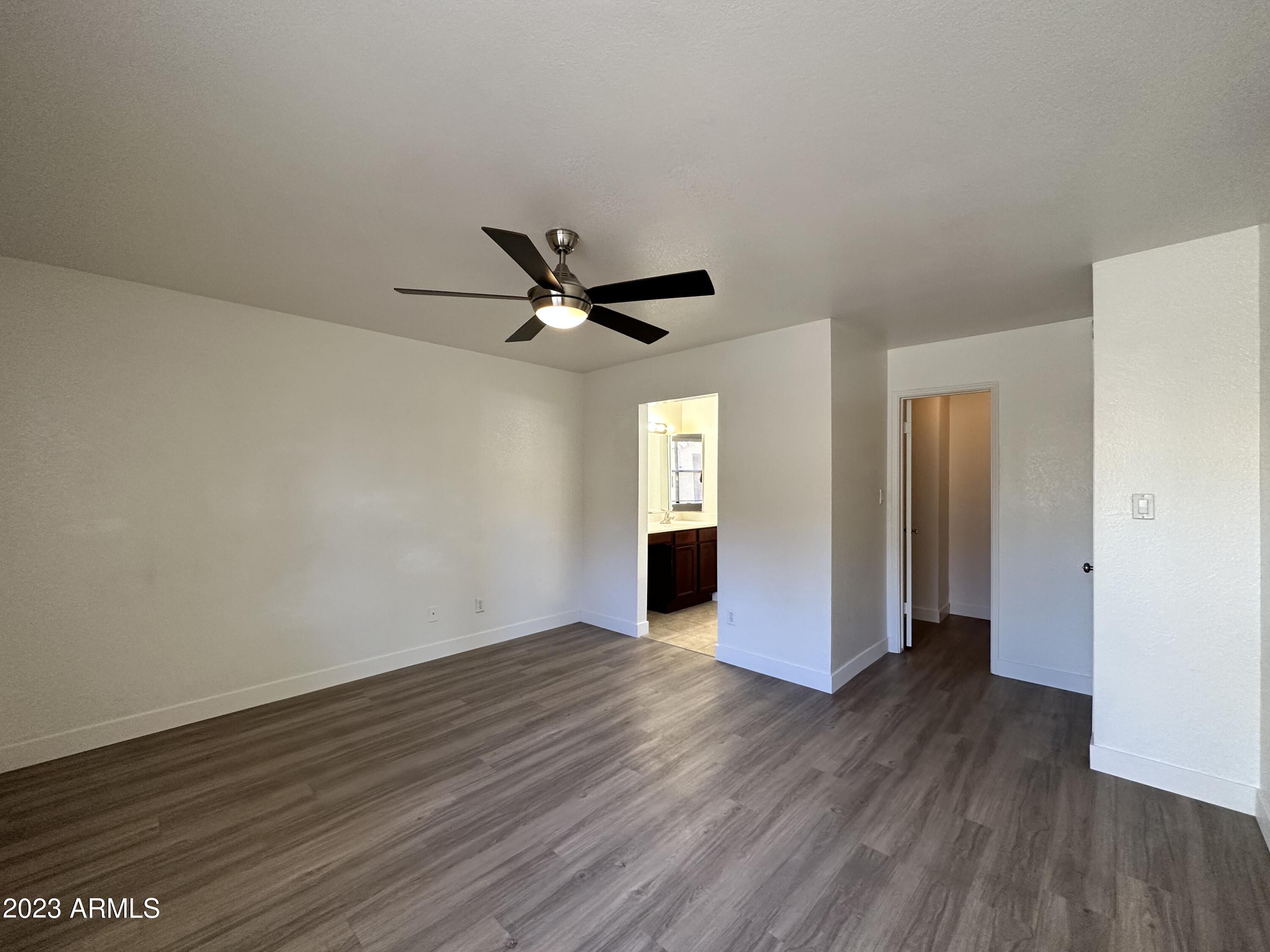 8787 East Mountain View Road, Unit 1103 Scottsdale, AZ 85258 - Photo 29 of 38 a view of a livingroom with wooden floor and a ceiling fan