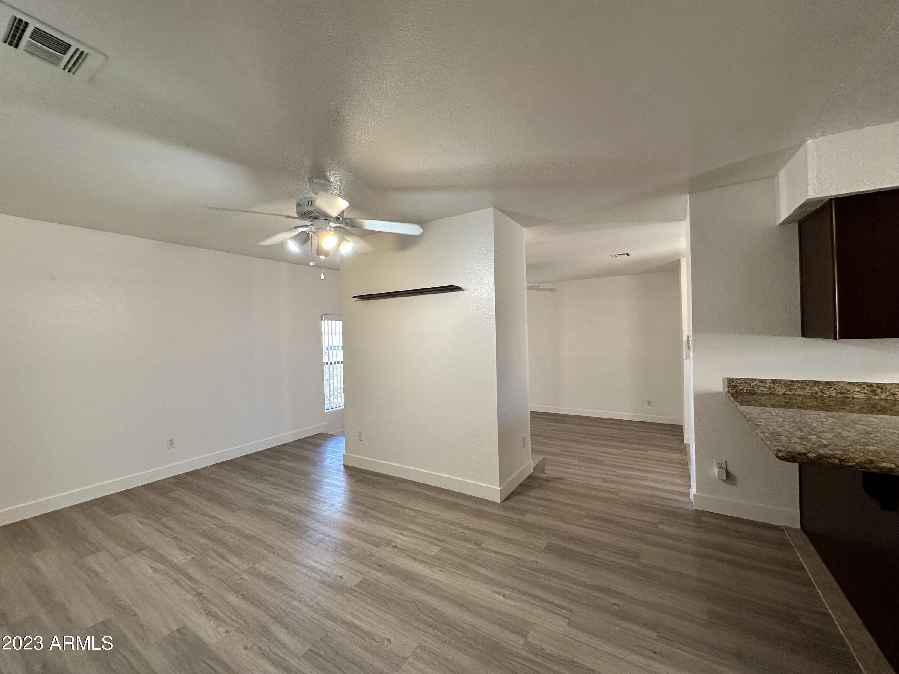 8787 East Mountain View Road, Unit 1103 Scottsdale, AZ 85258 - Photo 36 of 38 wooden floor in an empty room with a chandelier fan