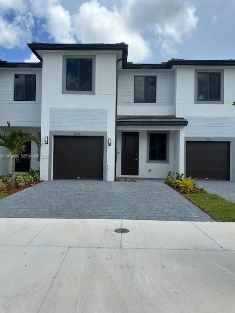 a front view of a house with yard and parking