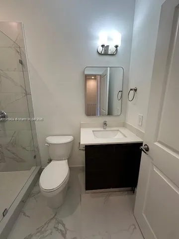 a bathroom with a sink vanity mirror and toilet