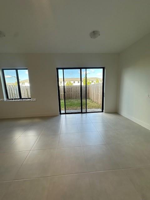 18975 Southwest 345th Terrace, Unit 18975 Homestead, FL 33034 - Photo 7 of 17 an empty room with large windows and city view