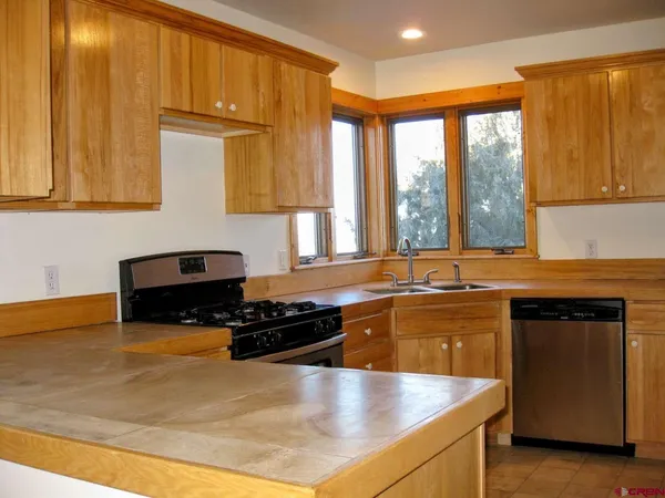 a kitchen with stainless steel appliances granite countertop a sink stove and cabinets
