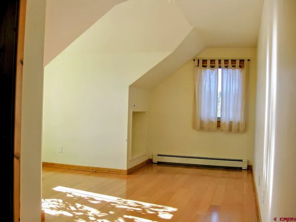 a view of a room with wooden floor and a window