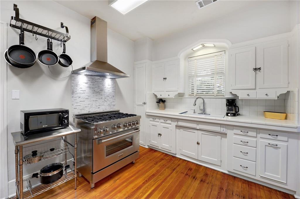 1604 South Main Street Georgetown, TX 78626 - Photo 13 of 25 a kitchen with cabinets stainless steel appliances and wooden floor