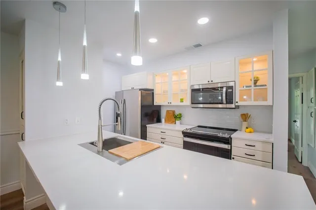 a kitchen with stainless steel appliances a stove sink and cabinets